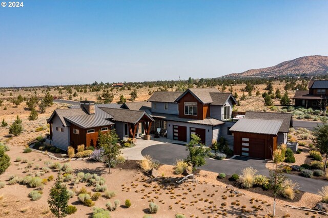 view of front of property with a mountain view, an outdoor structure, and a garage