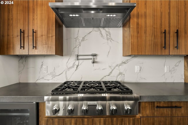 kitchen featuring stainless steel gas stovetop, ventilation hood, backsplash, and wine cooler