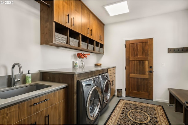 laundry area with cabinets, washing machine and dryer, and sink