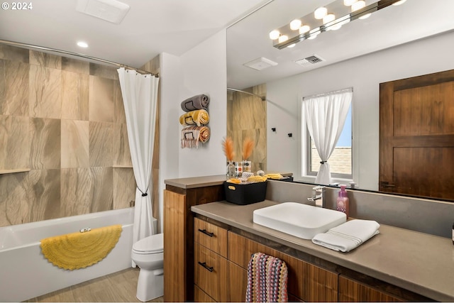 full bathroom featuring vanity, shower / tub combo with curtain, and toilet