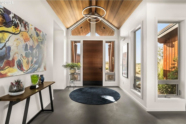 foyer entrance featuring a wealth of natural light, vaulted ceiling, concrete floors, and wood ceiling