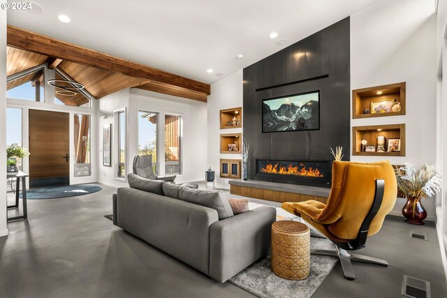 living room with built in features, concrete flooring, a large fireplace, high vaulted ceiling, and beamed ceiling