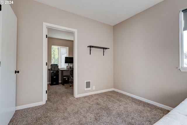 unfurnished bedroom with carpet and a textured ceiling