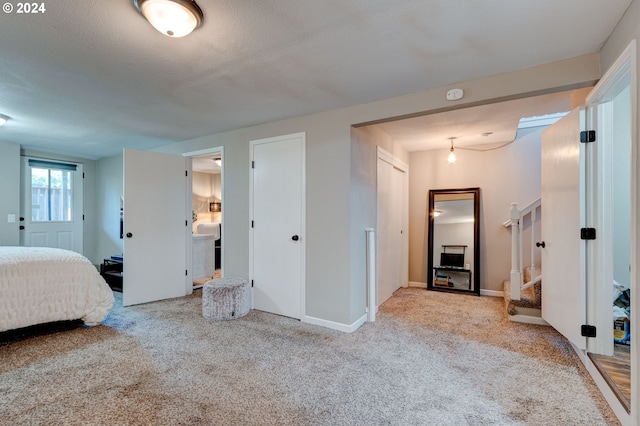 bedroom with a textured ceiling and light colored carpet