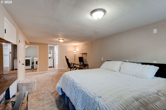 bedroom with a textured ceiling, carpet, and independent washer and dryer