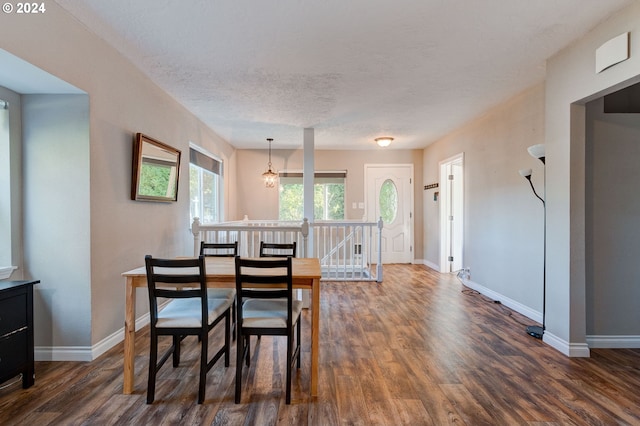 dining room featuring a textured ceiling, dark hardwood / wood-style floors, and a notable chandelier