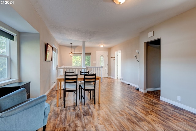 dining space with a textured ceiling and hardwood / wood-style floors