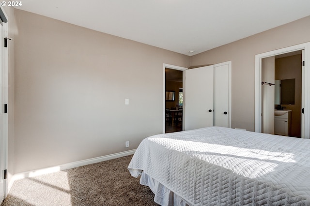 carpeted bedroom featuring ensuite bath