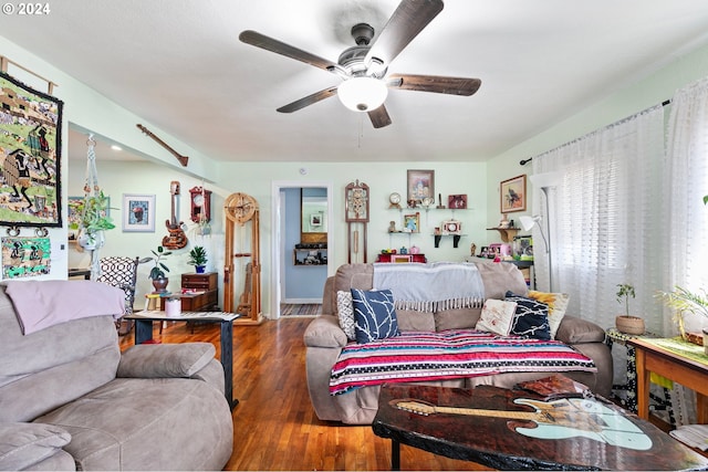 living room with dark wood-type flooring and a ceiling fan