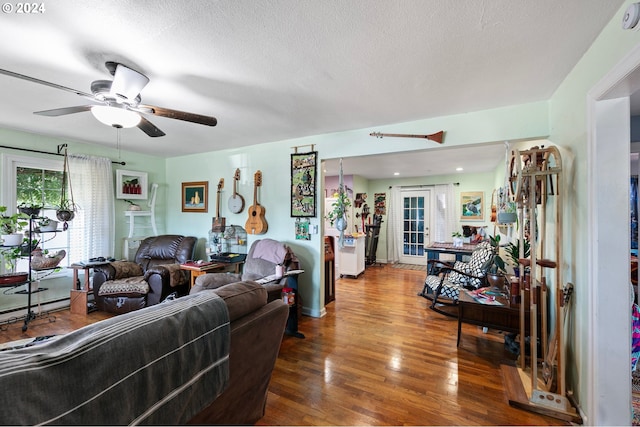 living room with french doors, hardwood / wood-style floors, ceiling fan, and a textured ceiling