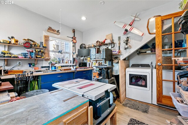 kitchen with washer / dryer, blue cabinets, and light hardwood / wood-style flooring