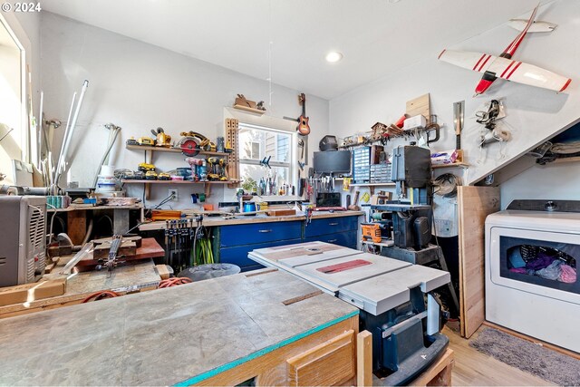 kitchen with washer / dryer, blue cabinetry, and light hardwood / wood-style floors