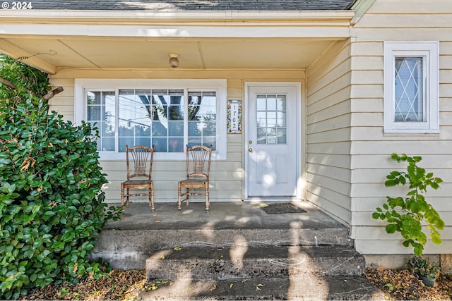 entrance to property with roof with shingles