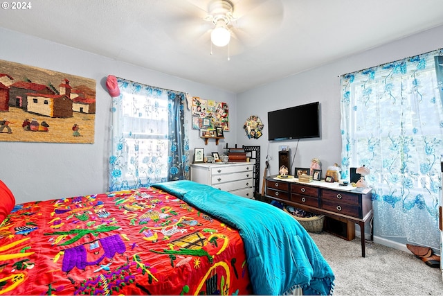 bedroom featuring a ceiling fan, light carpet, and baseboards