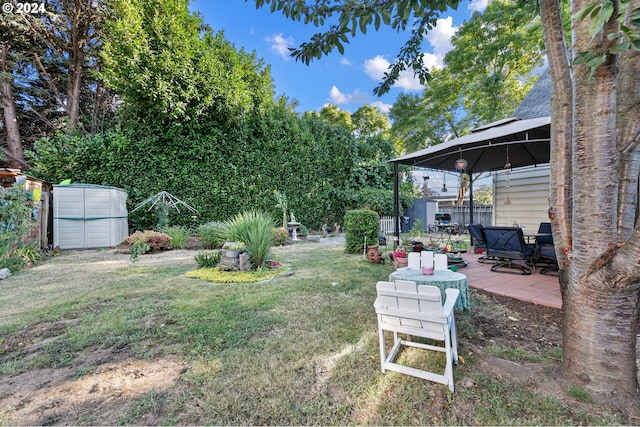 view of yard with a gazebo, a patio area, an outdoor structure, and a storage shed