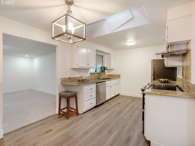 kitchen with white cabinets, pendant lighting, light carpet, a skylight, and stainless steel appliances