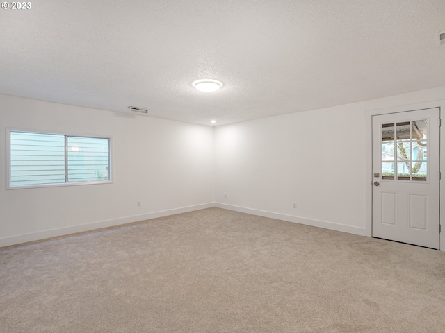 carpeted spare room featuring a textured ceiling