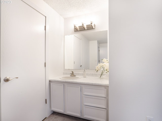 bathroom featuring a textured ceiling and vanity