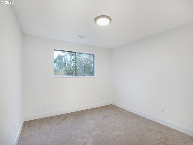 spare room featuring light colored carpet