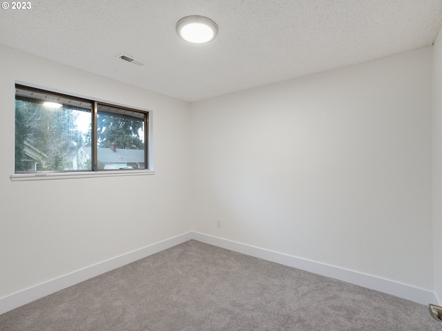 carpeted empty room with a textured ceiling