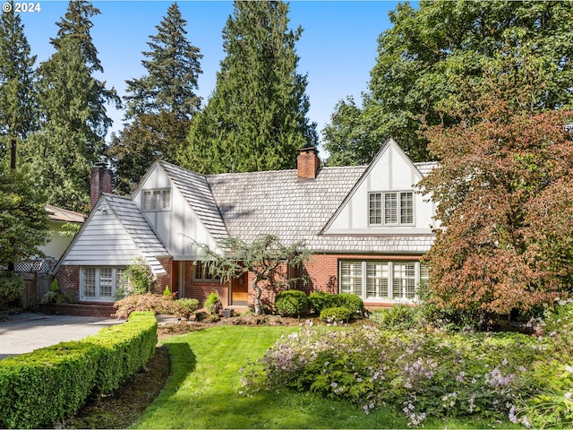 tudor home with a front lawn