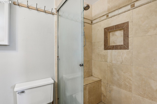 bathroom with toilet and a tile shower