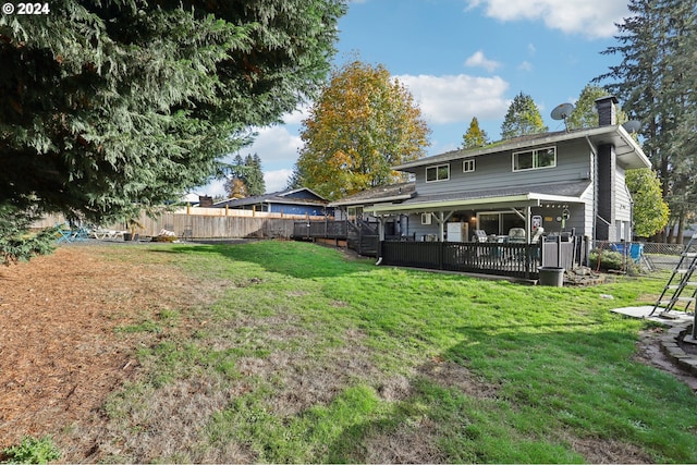 back of property with a lawn and a deck