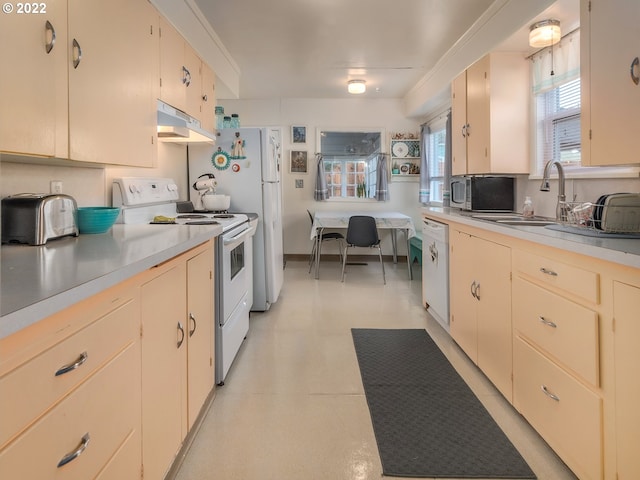 kitchen featuring white appliances, cream cabinetry, and sink