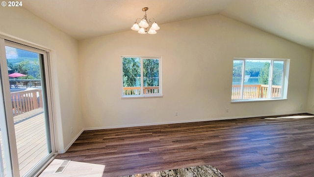 unfurnished room featuring lofted ceiling, dark hardwood / wood-style floors, and a chandelier