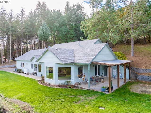 rear view of house featuring a lawn and a patio area