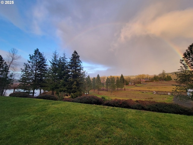 yard at dusk featuring a water view