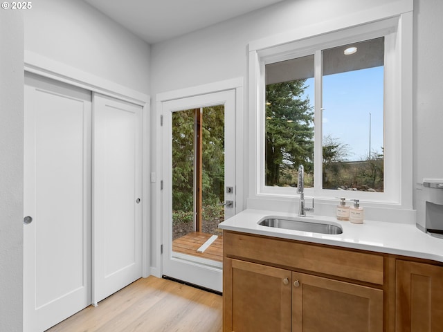 doorway featuring a sink and light wood finished floors