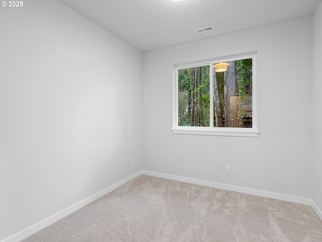 carpeted spare room with baseboards and visible vents