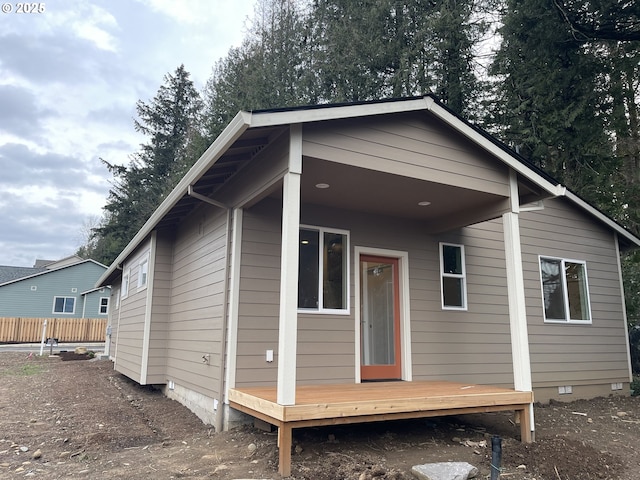 rear view of house featuring crawl space and fence