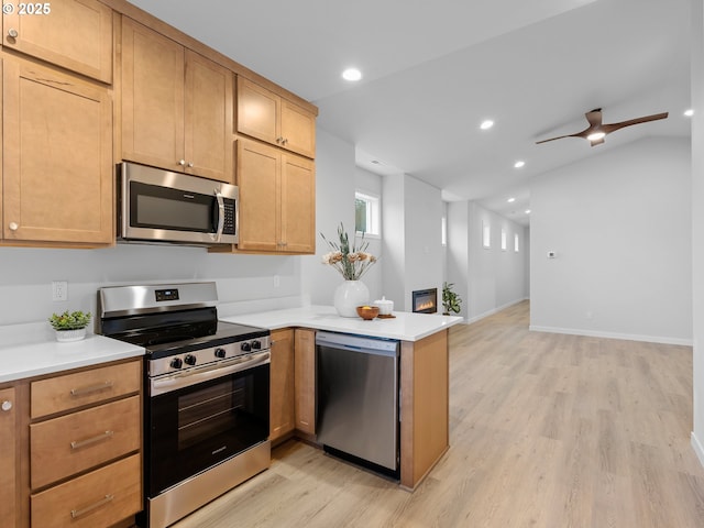 kitchen with stainless steel appliances, light wood-type flooring, a peninsula, and light countertops