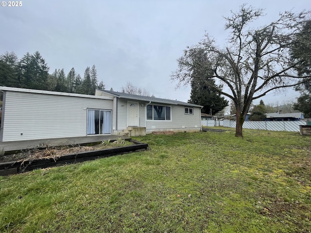 rear view of house featuring a yard