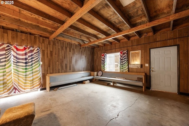 interior space with concrete flooring and wooden walls