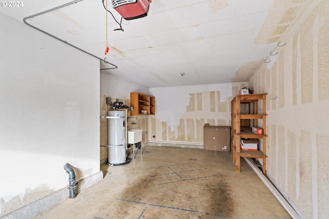 garage featuring sink, strapped water heater, and a garage door opener