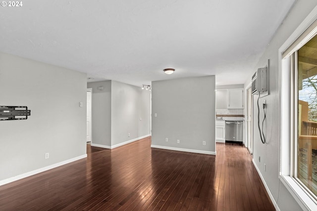 unfurnished living room featuring a wall unit AC and dark hardwood / wood-style flooring