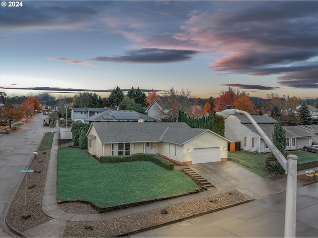 view of front of house with a garage and a yard