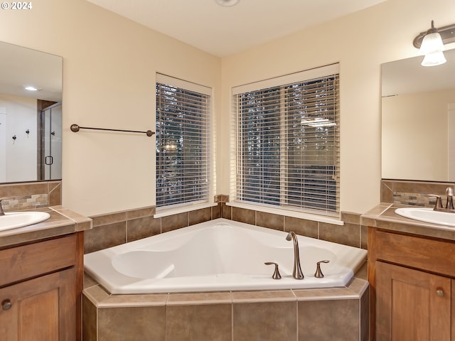 bathroom featuring shower with separate bathtub and vanity