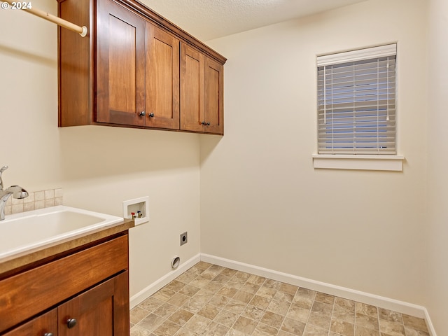 washroom featuring sink, cabinets, electric dryer hookup, hookup for a washing machine, and a textured ceiling