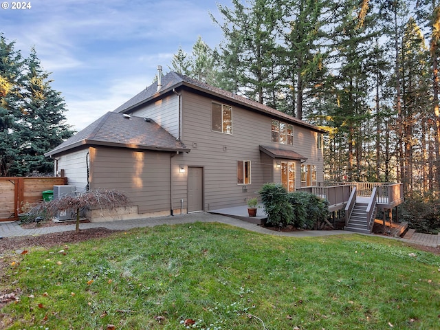 rear view of house with a yard, a patio, and a deck