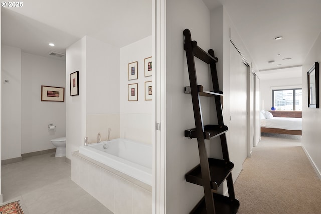 bathroom featuring toilet and tiled tub