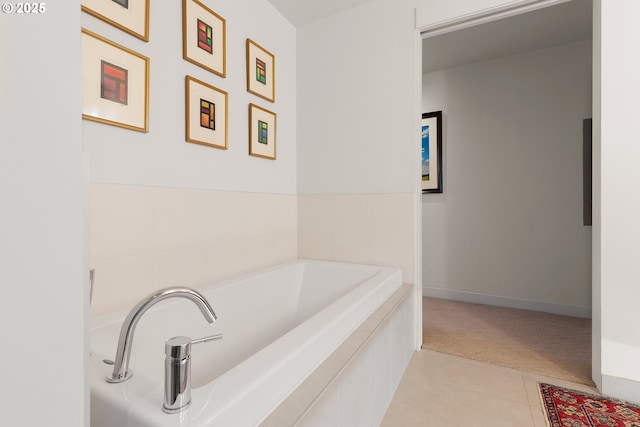 bathroom with tile patterned floors and a bath