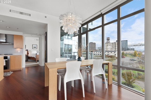 dining room with a notable chandelier, expansive windows, and dark hardwood / wood-style flooring