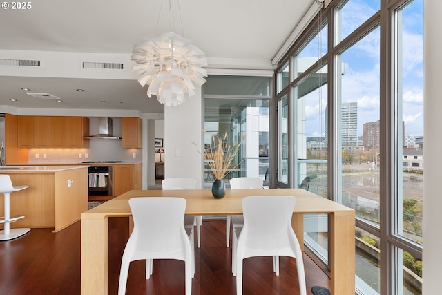 dining area with floor to ceiling windows, a wealth of natural light, dark hardwood / wood-style floors, and a notable chandelier