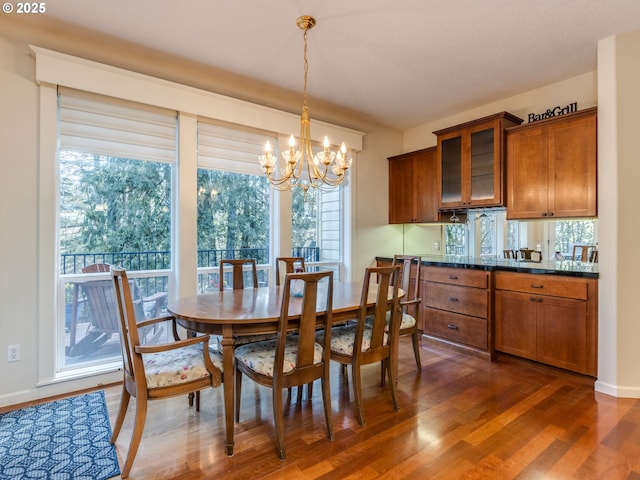 dining space featuring dark wood finished floors and a notable chandelier