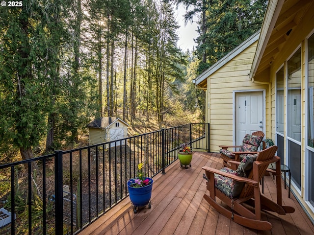 wooden terrace featuring an outdoor structure and a shed