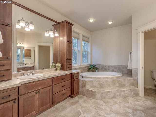 bathroom featuring toilet, a bath, vanity, and tile patterned flooring